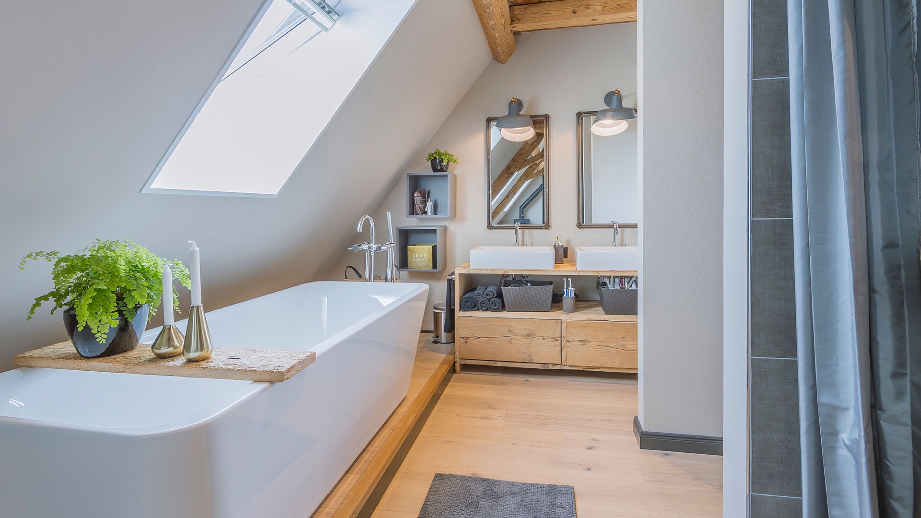 Bad unter dem Dachfenster mit Wanne auf Holzpodest