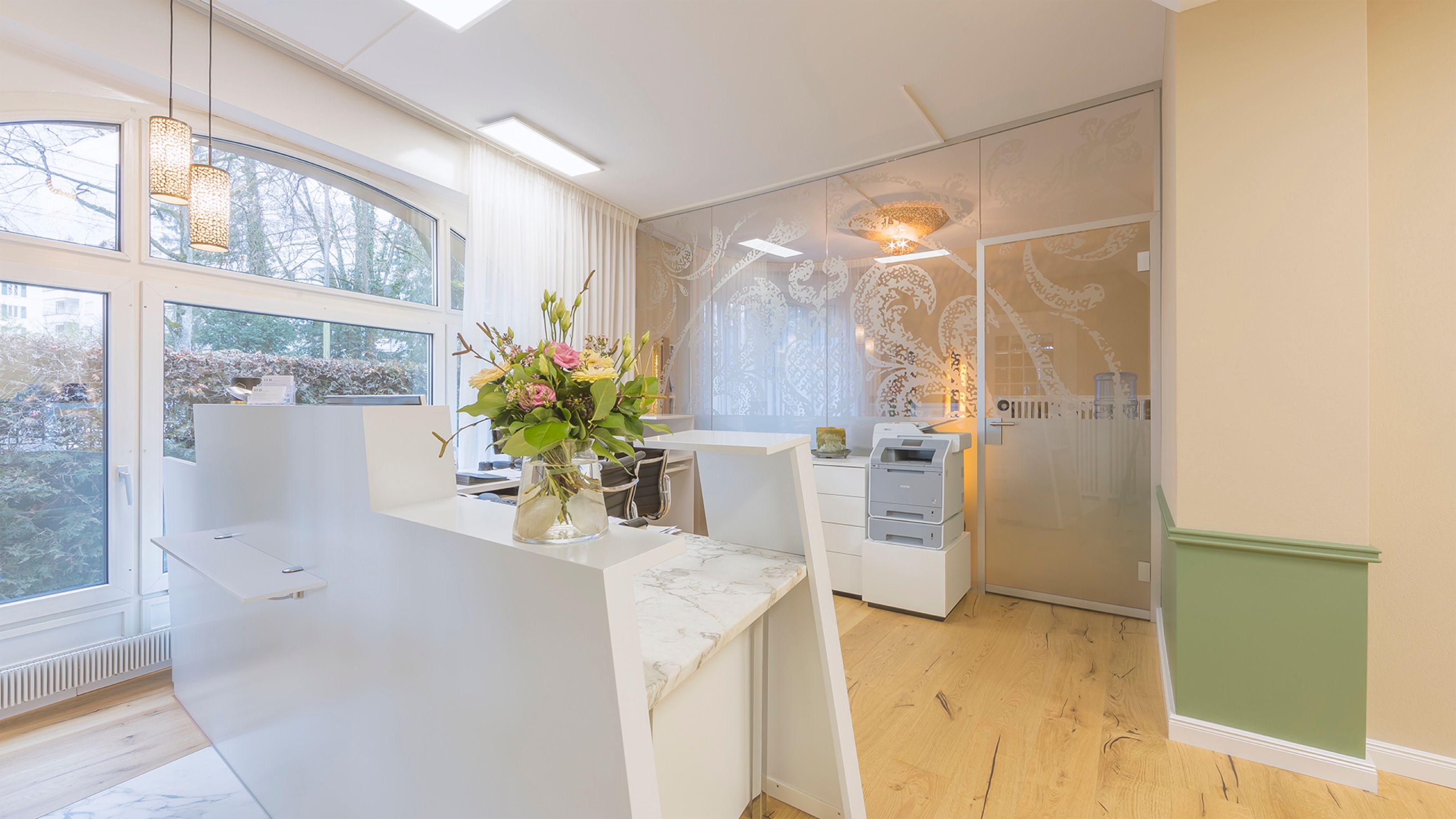 Heller Empfangsbereich mit Theke in Marmoroptik
